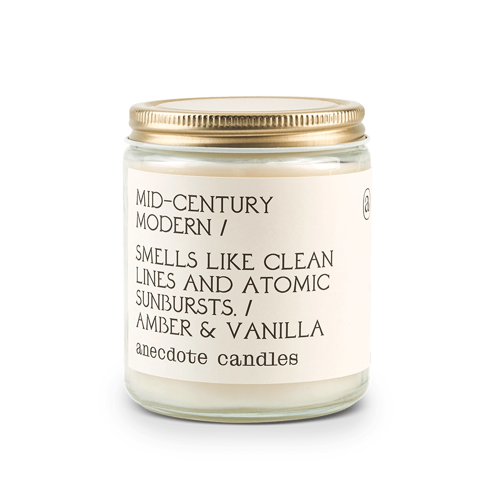 Anecdote candle with label reading Mid-century Modern / Smells like clean lines and atomic sunbursts. / Amber and vanilla.