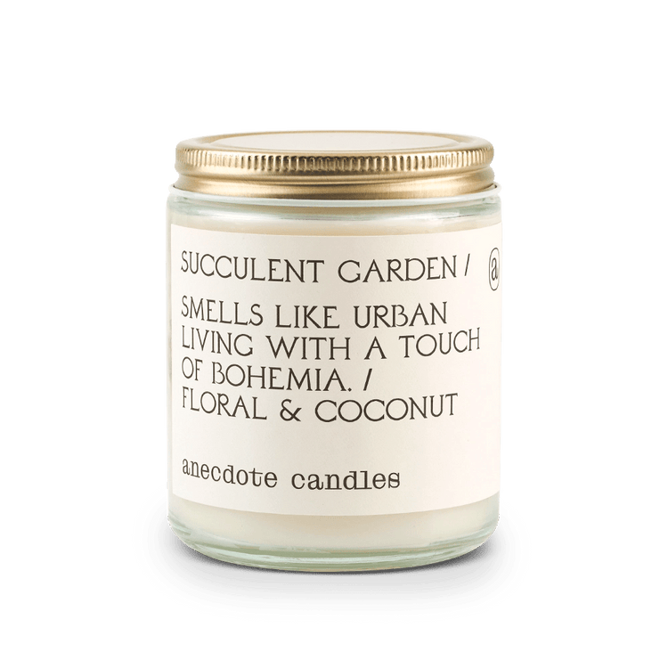 Candle with label that reads Succulent Garden / Smells like urban living with a touch of bohemia. / Floral and coconut.